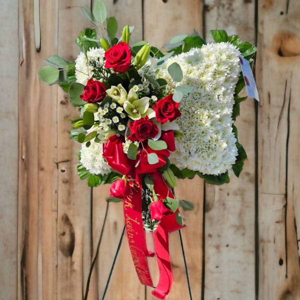 Standing floral heart wreath with red roses and white blooms on an easel