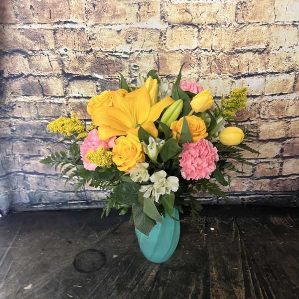 Yellow and pink mixed bouquet in a turquoise vase