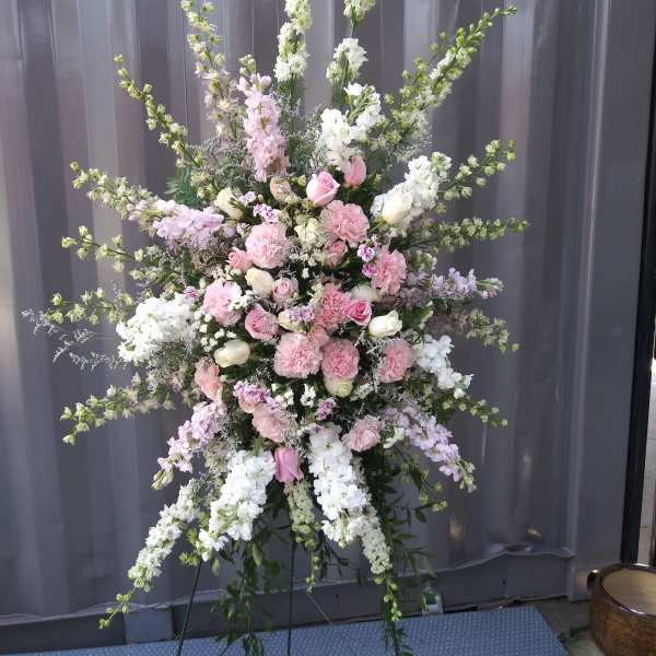 Tall pink and white floral standing spray on an easel