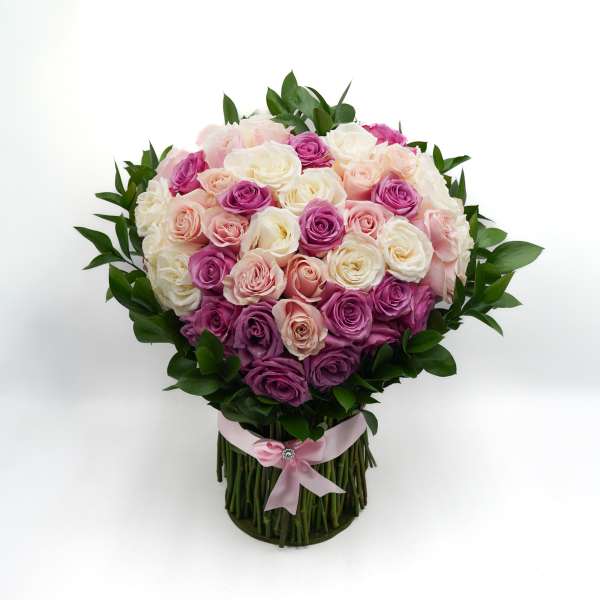 Bouquet of pink, white, and purple roses with a pink ribbon wrap