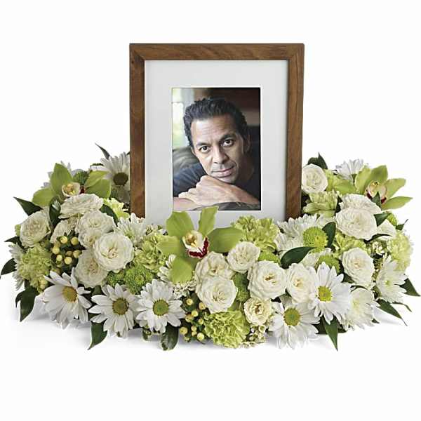 White floral photo frame arrangement with a portrait in the center