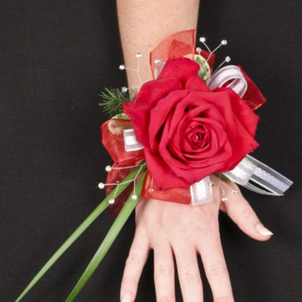 Red rose wrist corsage with ribbon and decorative accents