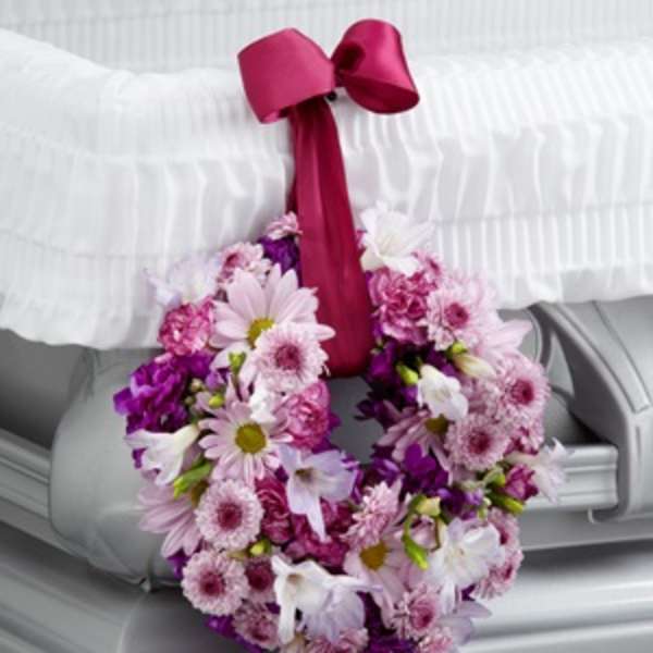 Pink and purple floral wreath with a magenta ribbon bow