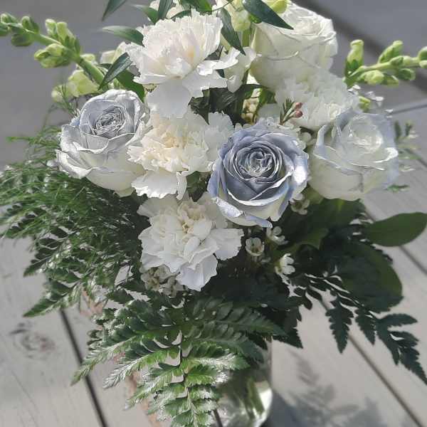 White and silver rose bouquet with carnations in a glass vase