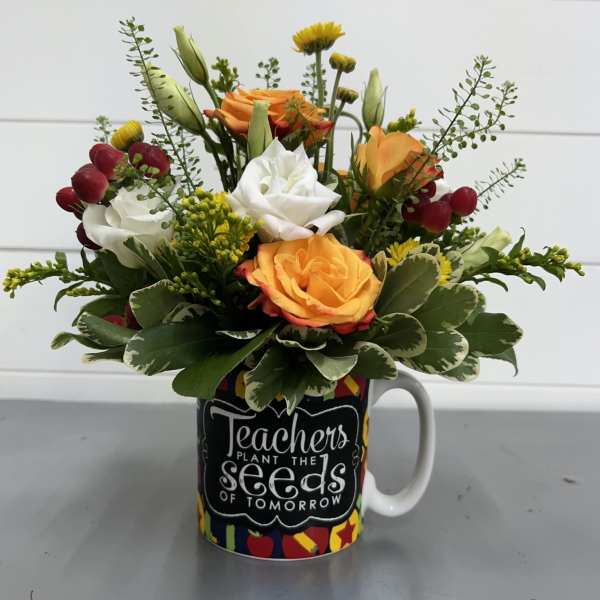 Mixed bouquet in a mug with orange, white, and red flowers