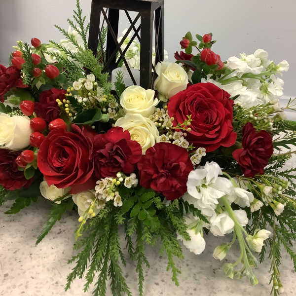 Red and white floral arrangement around a black lantern