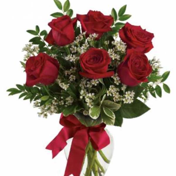 Bouquet of red roses with white filler in a clear glass vase