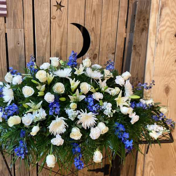 Large white and blue floral arrangement on a stand