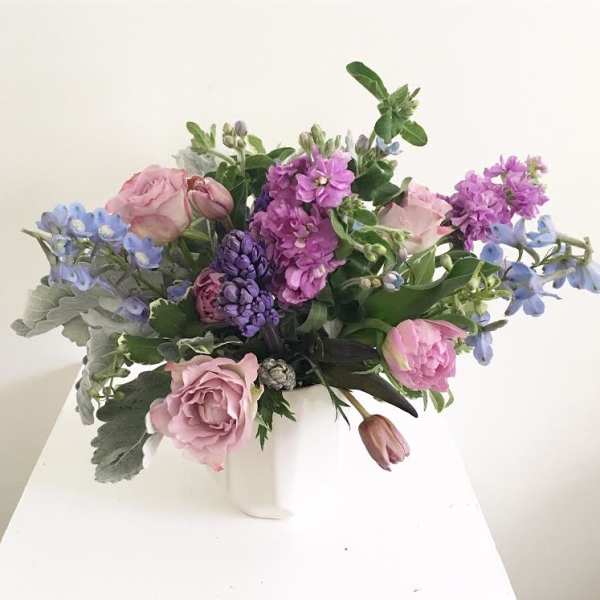 Pink and purple flower arrangement in a white vase