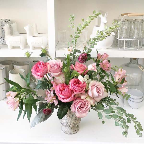 Pink roses and alstroemeria arranged in a speckled vase