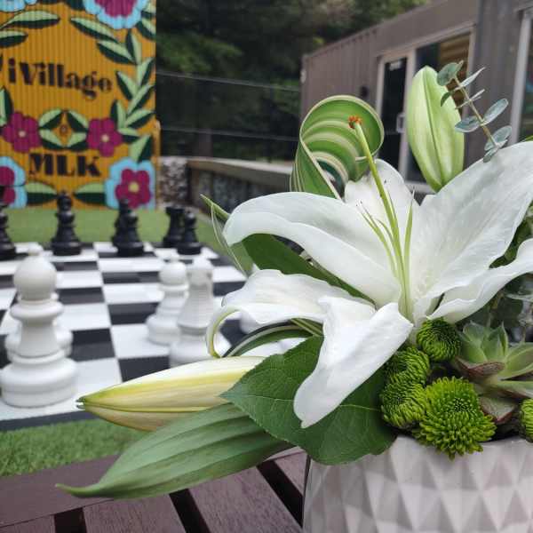 White lilies and green mums in a white vase