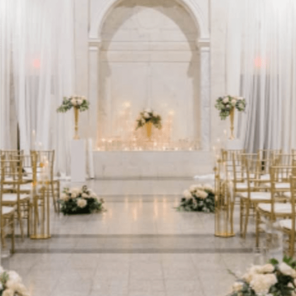 White floral wedding aisle with gold chairs and altar arrangements