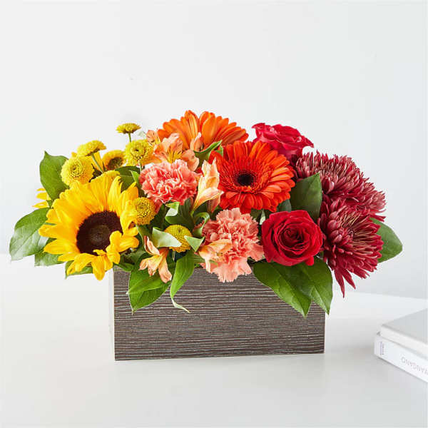 Mixed bouquet in a rectangular wooden box with sunflowers, roses, and mums