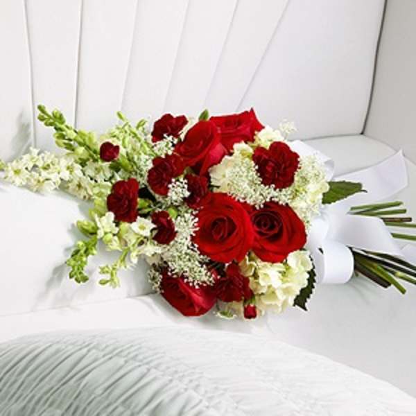 Bouquet of red roses and white flowers wrapped in white paper