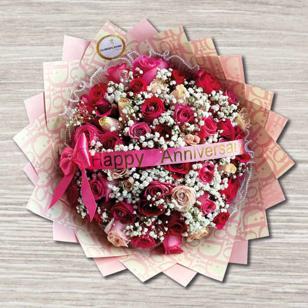 Pink and red rose bouquet with baby's breath and a Happy Anniversary ribbon