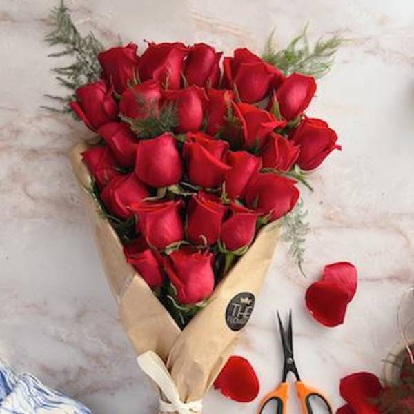 Bouquet of red roses wrapped in tan paper