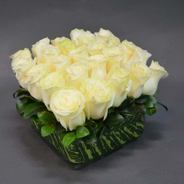 Cream rose arrangement in a low square vase