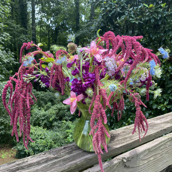 Large bouquet of pink, purple, and blue flowers in a glass vase