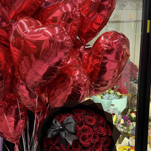 Red rose bouquet with a black ribbon and red heart balloons