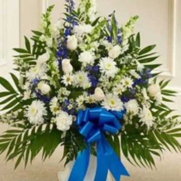 White and blue floral standing spray with a blue ribbon