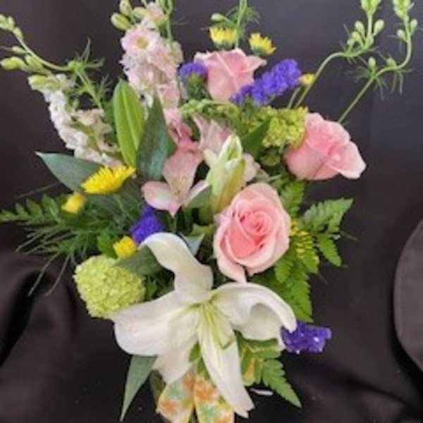 Bouquet of pink roses, white lilies, and purple accents