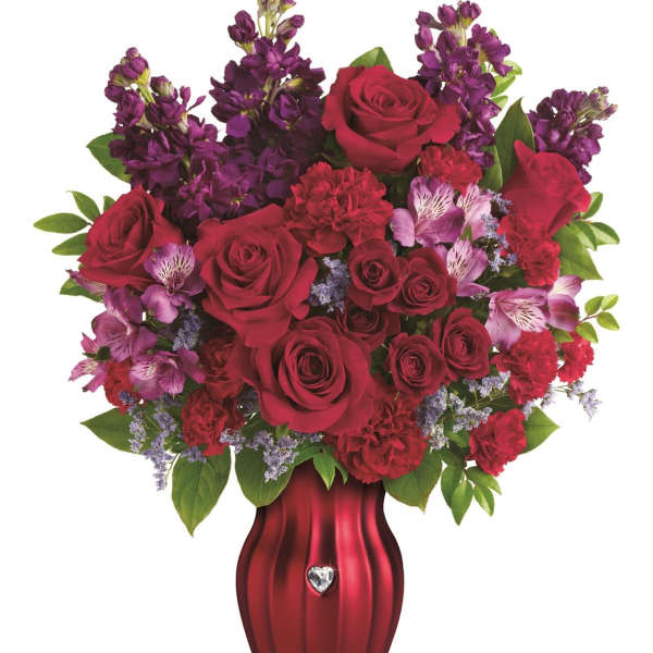Red roses and purple flowers arranged in a red vase