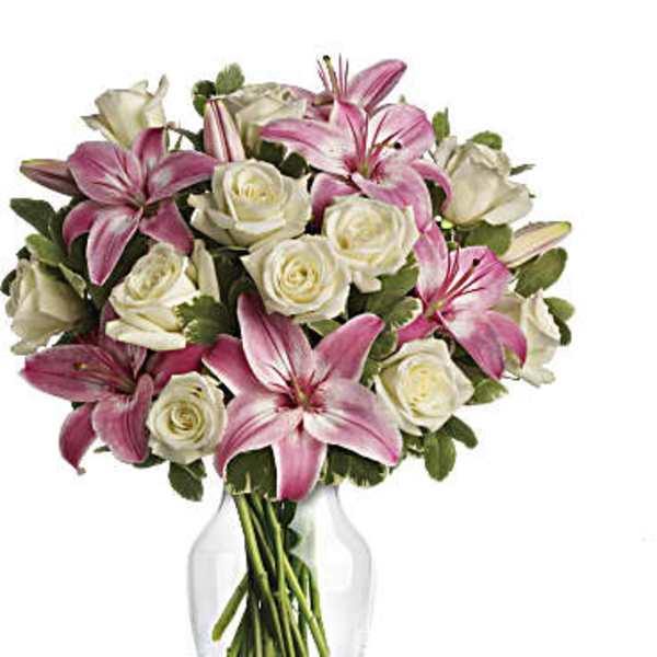 Bouquet of pink lilies and white roses in a clear glass vase