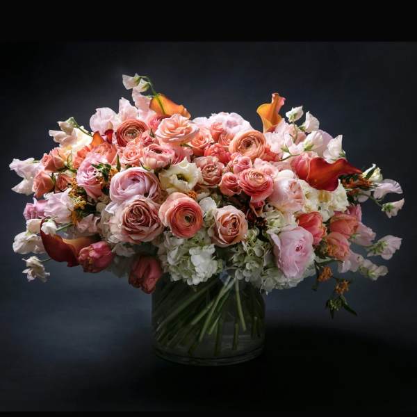 Large bouquet of pink and peach roses in a glass vase