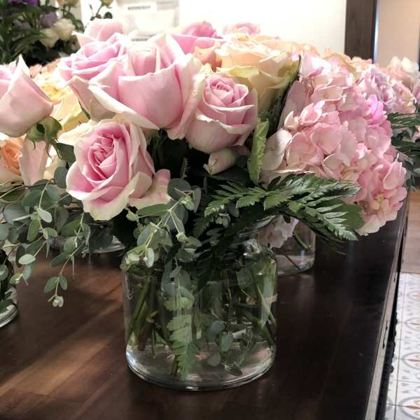 Pink and cream roses with hydrangeas in a glass vase