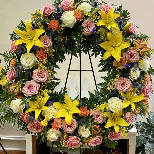 Large floral wreath with pink and white roses and bright yellow lilies