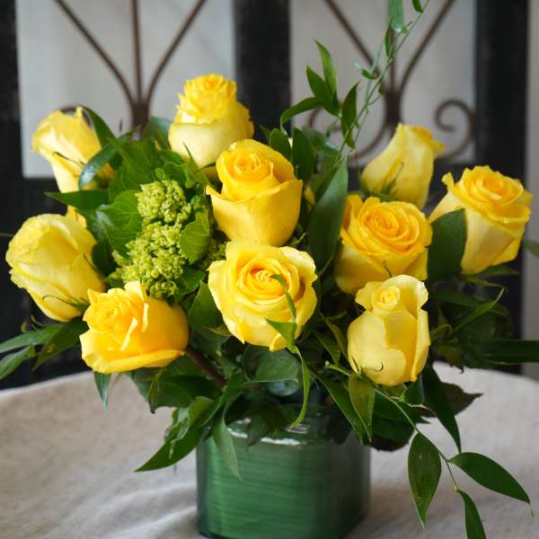 Yellow roses arranged in a green square vase