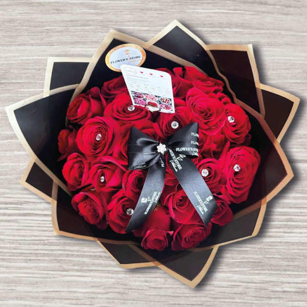 Bouquet of red roses wrapped in black paper with a ribbon