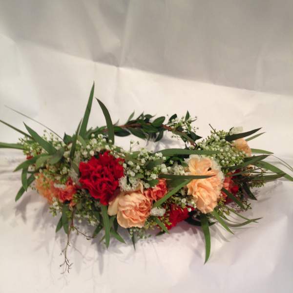 Low floral arrangement with red and peach carnations and greenery