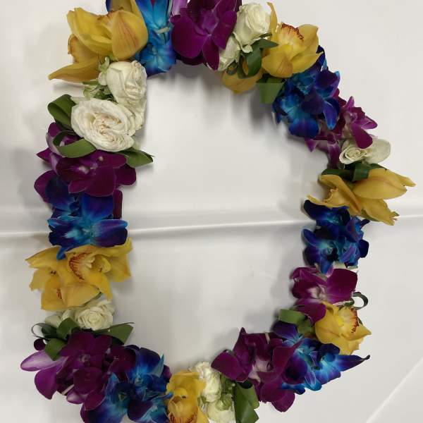 Colorful floral wreath with orchids and roses on a white surface