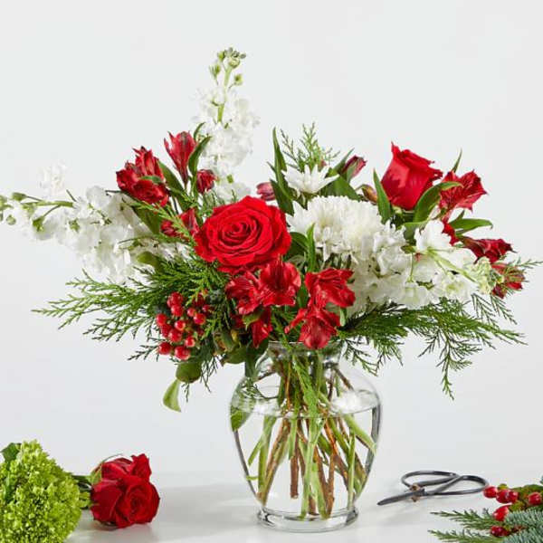 Red and white floral arrangement in a clear glass vase