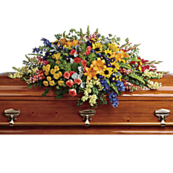Colorful floral spray arranged on a wooden casket