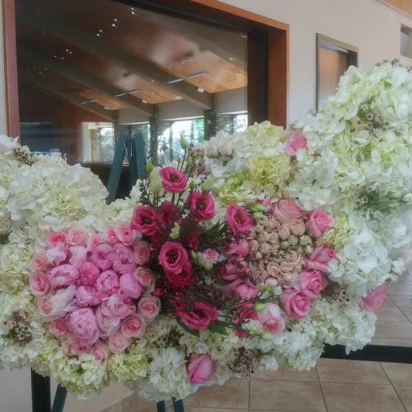 Large floral arrangement of white and pink flowers on a stand