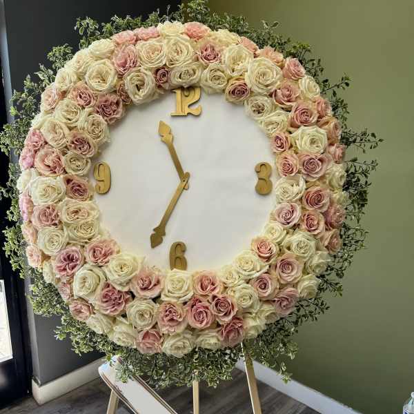 Large floral clock display covered in cream and blush roses
