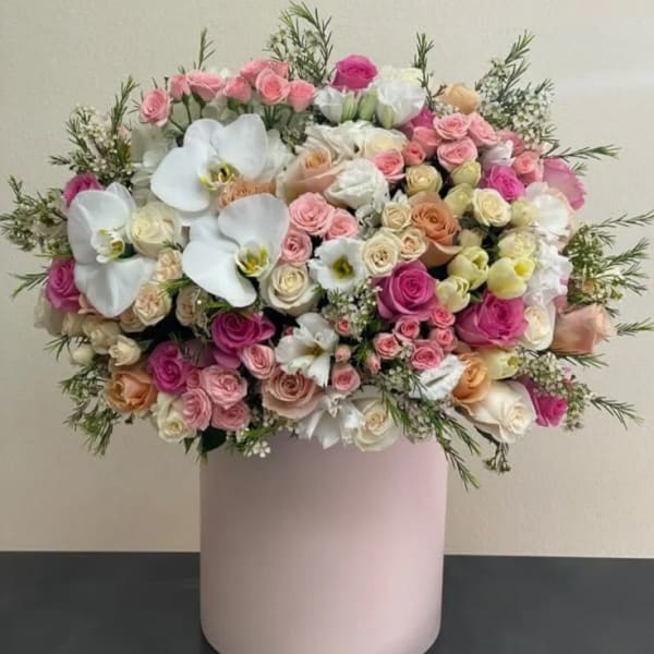 Large bouquet of pink and white roses in a pale pink vase
