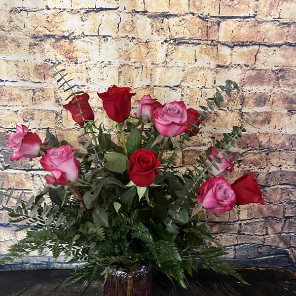 Pink and red roses arranged in a purple vase