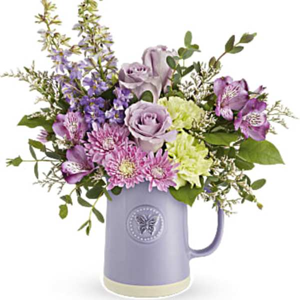 Lavender and purple flowers arranged in a lilac mug vase
