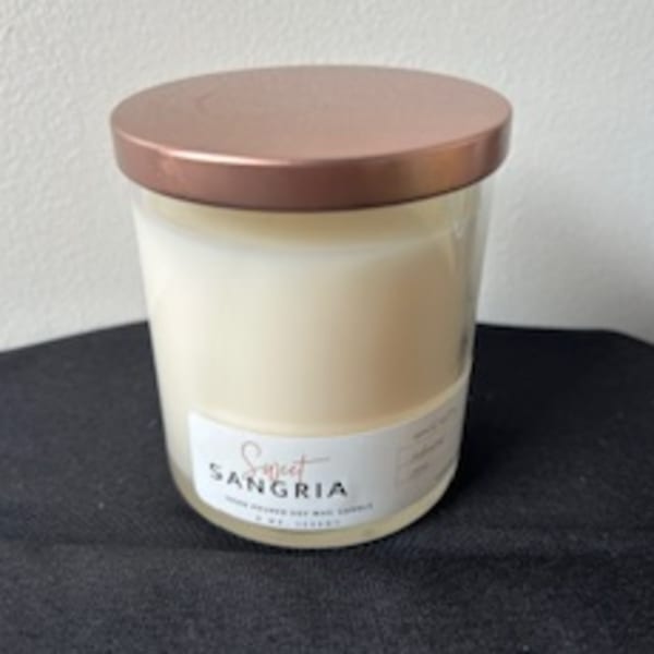 Cream-colored candle in a glass jar with a copper lid