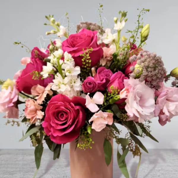 Pink and white rose bouquet in a peach vase