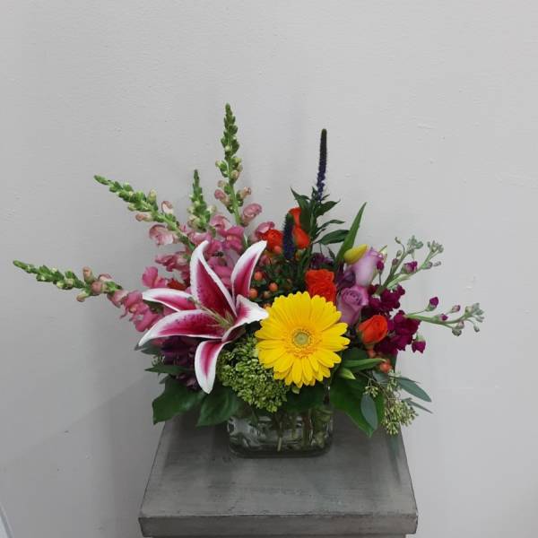 Mixed bouquet in a glass vase with a yellow gerbera and pink lily