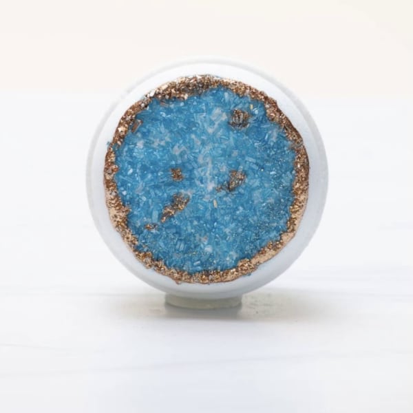 Round decorative glass orb with blue crystal center and copper rim