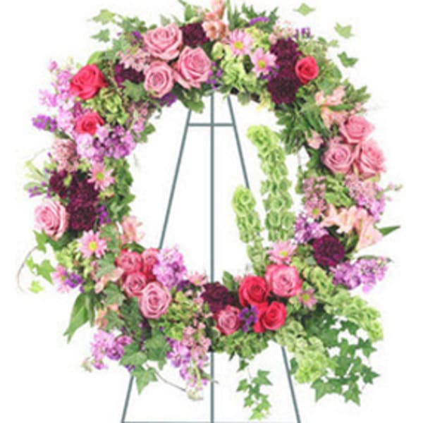 Large floral wreath on a metal easel with pink and purple flowers