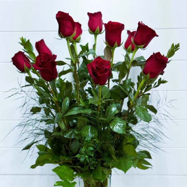 Tall bouquet of red roses in a clear glass vase
