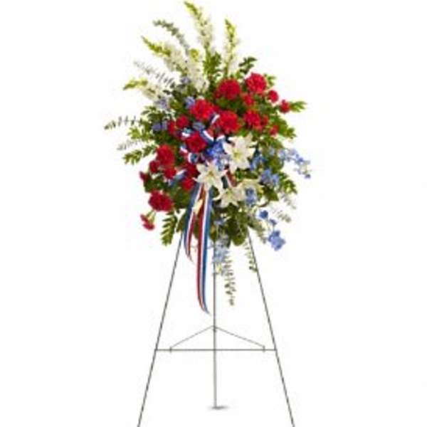 Standing floral spray with red, white, and blue flowers on an easel