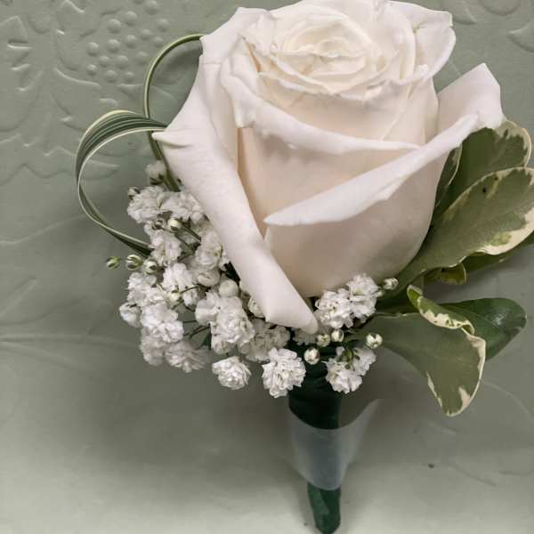 White rose boutonniere with baby's breath and variegated leaves