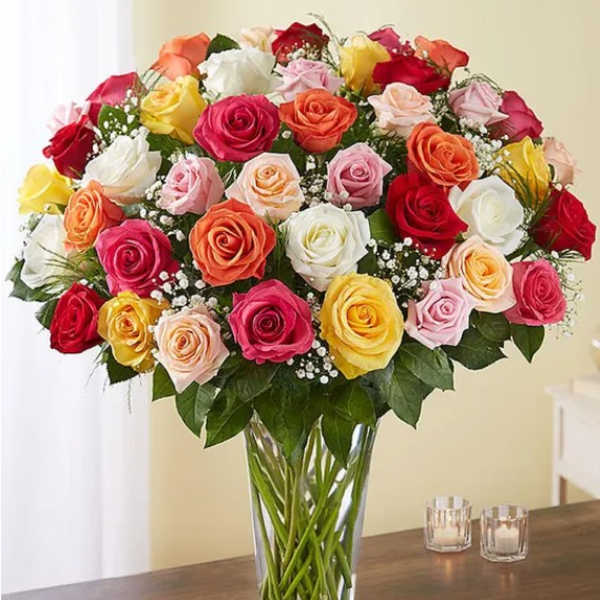 Mixed roses in many colors arranged in a clear glass vase